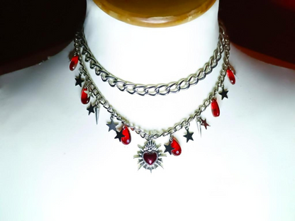 Necklace with red beads and star-shaped charms on a mannequin.